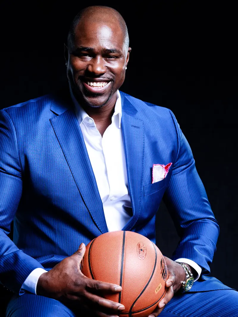 Gary Durrant in a blue suit, holding a basketball